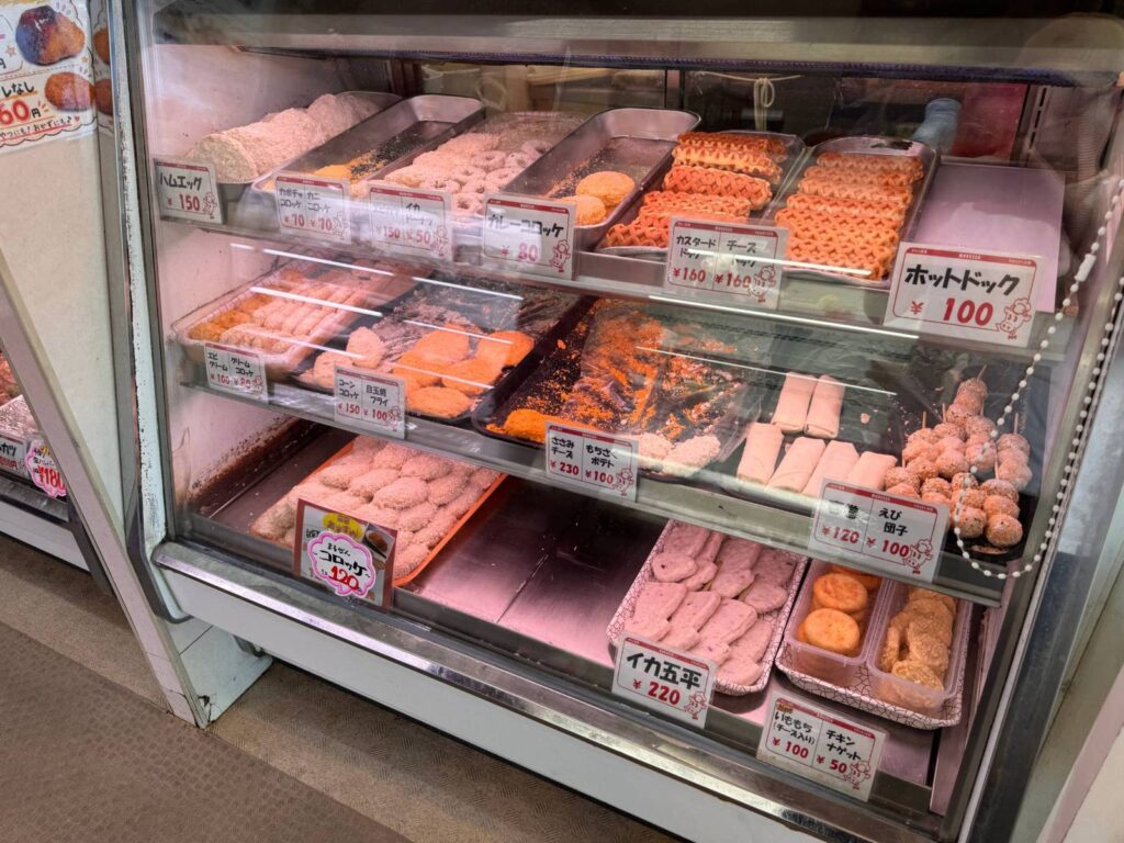 まるぜん精肉の揚げ物ケース(揚げる前のコロッケやホットドッグ)