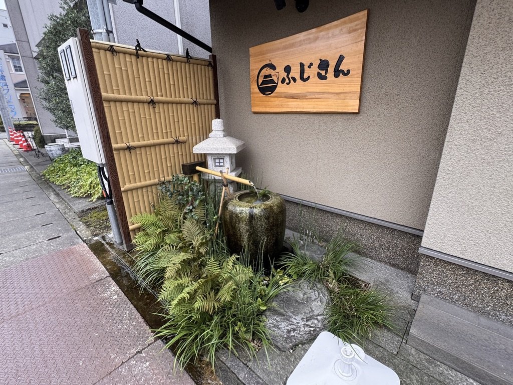 ふじさん富山店の入口横の竹垣と石灯籠、つくばい