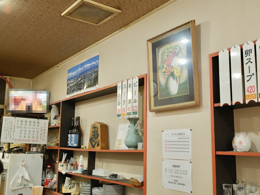 餃子会館 桜町支店 店内の壁(立山の写真とメニューの札)