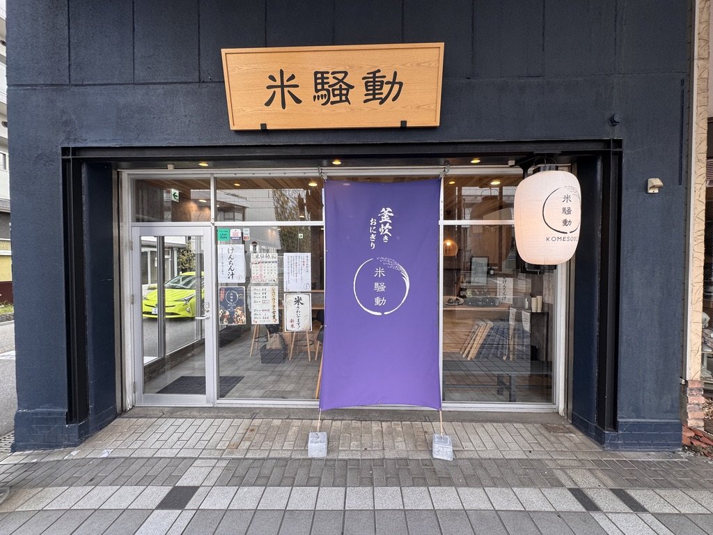 米騒動の店の正面(木の看板と紫ののれん、ちょうちん)