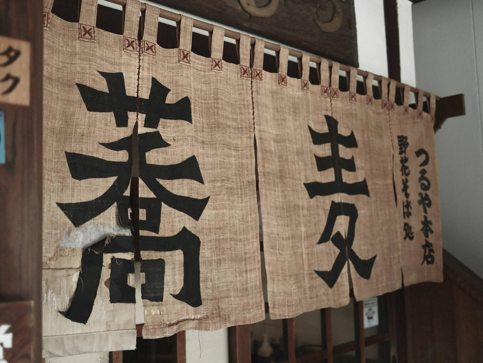 野花そば処 つるや本店 繕いのあとが残る蕎麦の暖簾